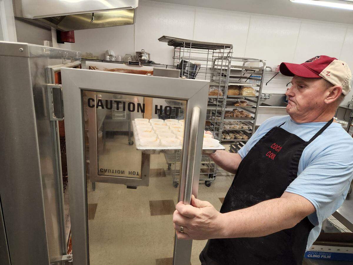 Breads and Such co-owner Chris Moore pops some sweet potato muffins into the oven at the new West Columbia bakery Breads and Such.