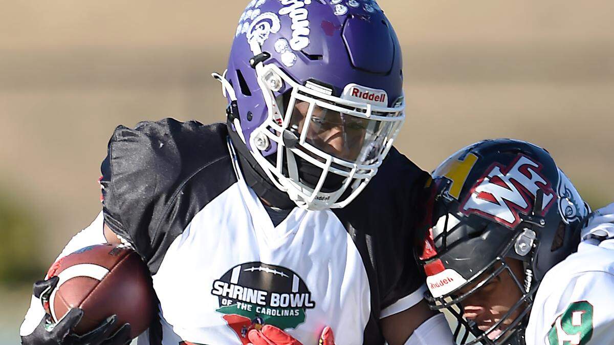 South Carolina’s Elijah Caldwell stiff arms North Carolina’s Tamarcus Cooley. The Shrine Bowl of the Carolinas 86th annual Shrine Bowl Game was played at Spartanburg High School Saturday, December 17, 2022. GWINN DAVIS MEDIA