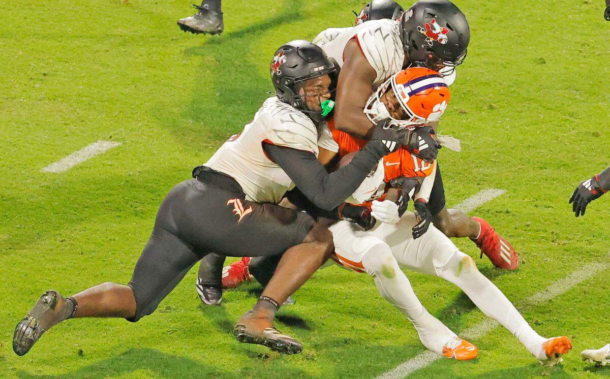Clemson wide receiver Bryant Wesco Jr. (12) is knocked down by Louisville during second-half action in Clemson, S.C. on Saturday, Nov. 2, 2024.