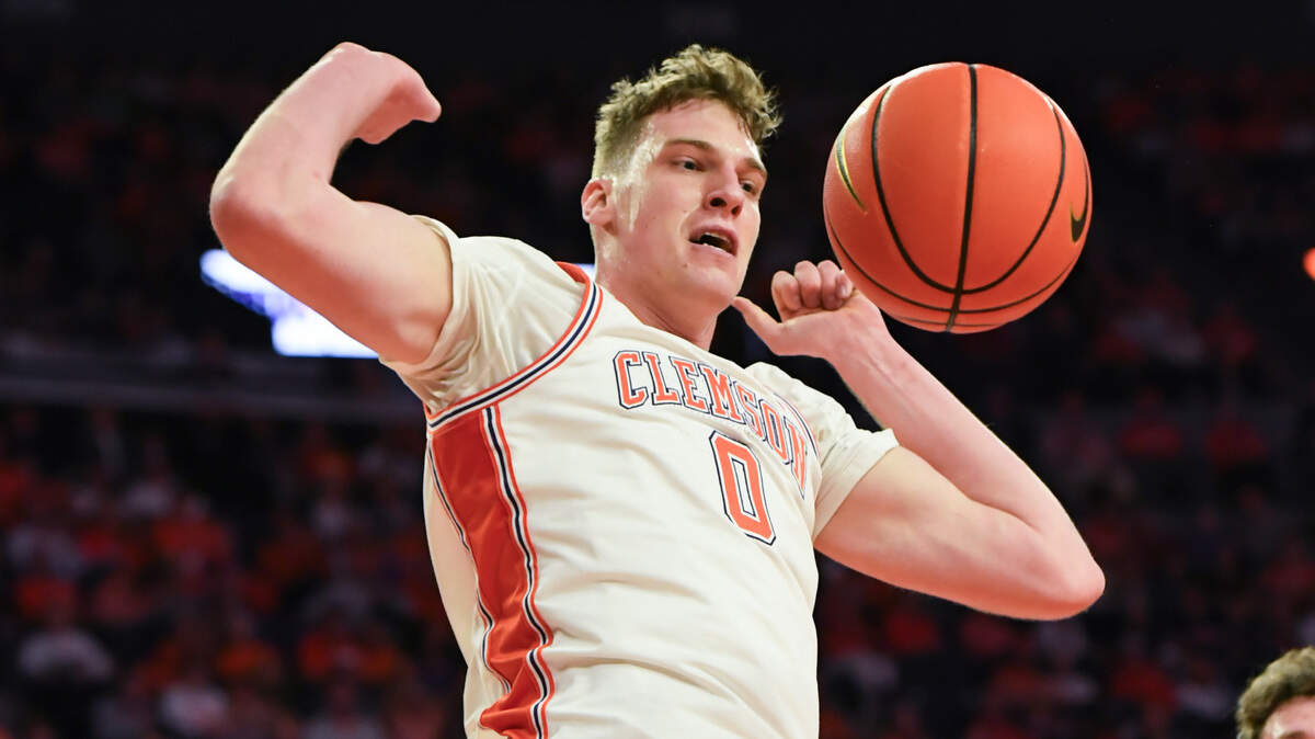 Mar 8, 2025; Clemson, SC, USA; Clemson senior center Viktor Lakhin (0) dunks near Virginia Tech forward Ben Burnham (13) during the first half at Littlejohn Coliseum in Clemson, S.C Saturday, March 8, 2025.