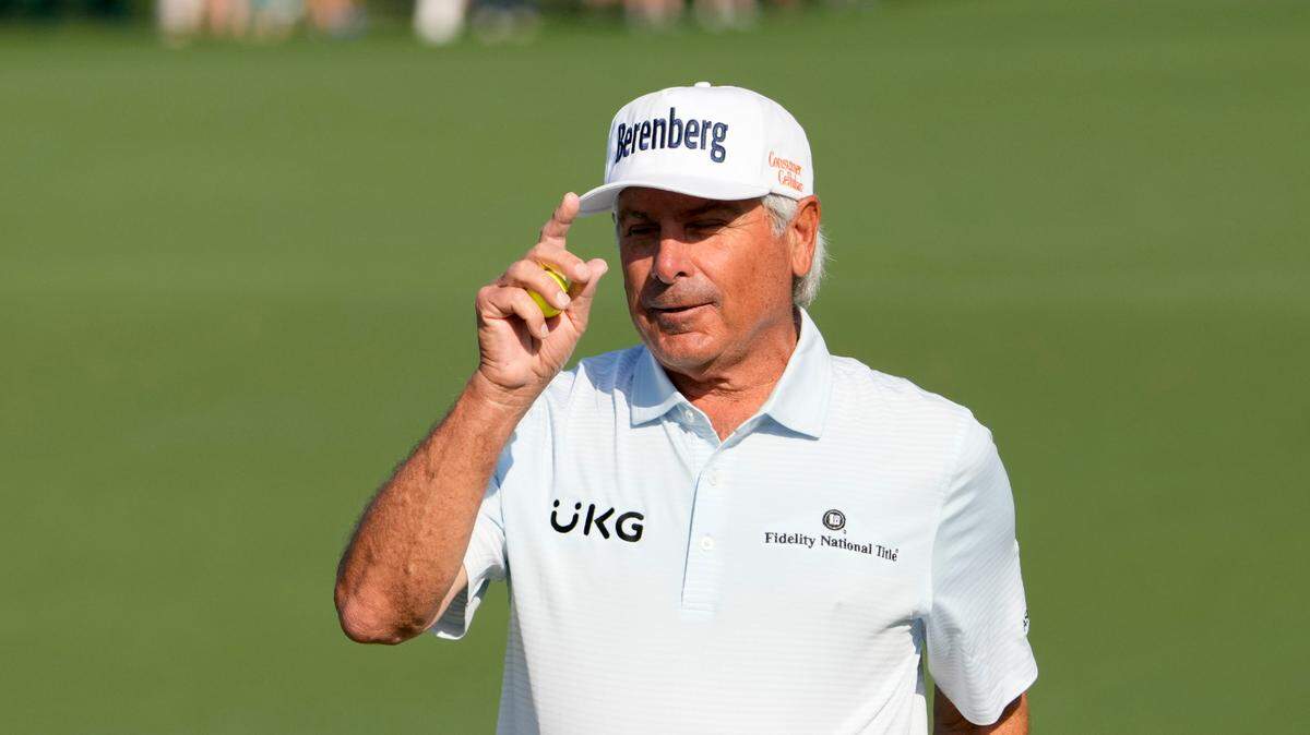 Fred Couples tips his hat to the crowd after sinking a putt on no. 2 during the first round of the Masters Tournament.