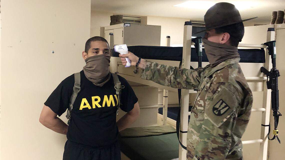 Senior drill sergeant Donald Castelow scans the temperature of trainee Victor Rios.