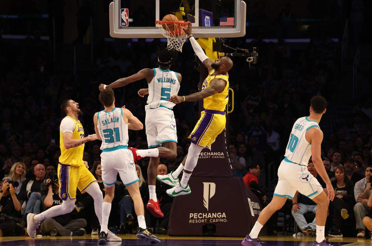 Feb 19, 2025; Los Angeles, California, USA; Los Angeles Lakers forward LeBron James (23) dunks over Charlotte Hornets center Mark Williams (5) Wednesday night at Crypto.com Arena.