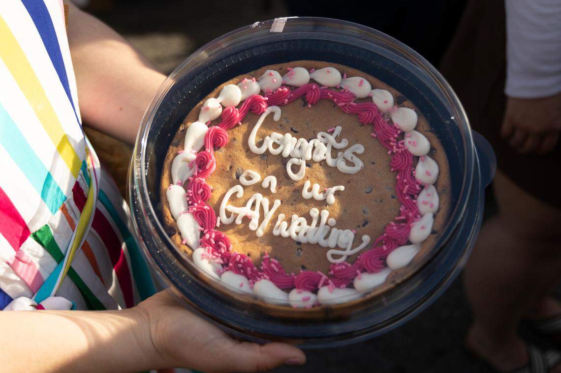 Friends of Christine Fowler and Sharon Thrailkill present a cookie cake to the couple at Y’all-Mart, a quarterly art fair series, at Art Bar in Columbia, South Carolina on Sunday, February 9, 2025. Thrailkill and Fowler were planning on marrying later in the year, but are unsure it will remain legal for them to marry by their original wedding date.