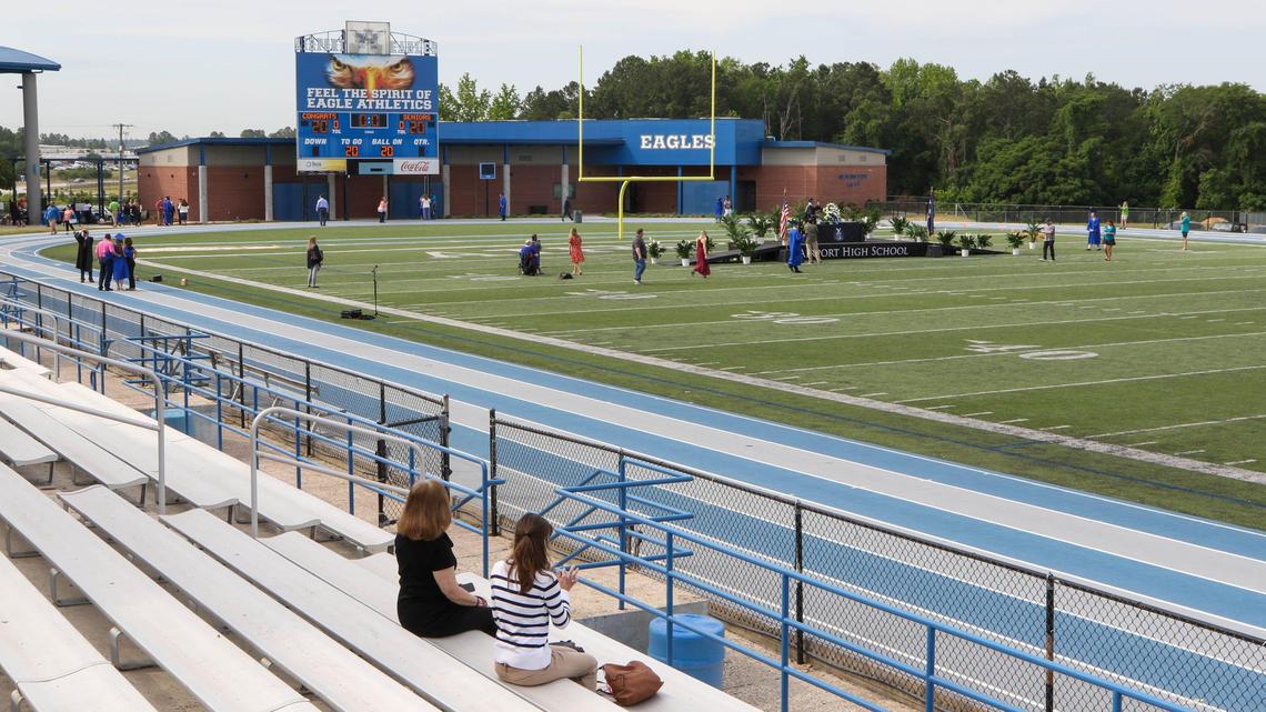 Leigh Chapman, left, and Kathy Zick watch as their grandson, Cory Chapman walks across the stage at Airport High School. After the risk of the coronavirus cancelled classes and a formal graduation ceremony, students were presented their diploma jackets and were photographed with family in an empty stadium where social distancing could be adhered to. Footage of the event will be combined with speeches and musical selections and will be packaged for each student as a memento. 5/13/20