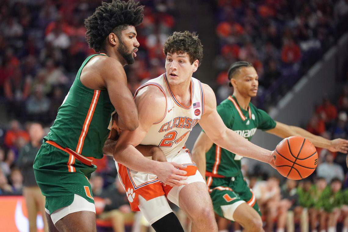 Clemson center PJ Hall (24) dribbles the ball against Miami forward Norchad Omier, left, during the first half of an NCAA college basketball game, Saturday, Feb. 4, 2023, in Clemson, S.C.