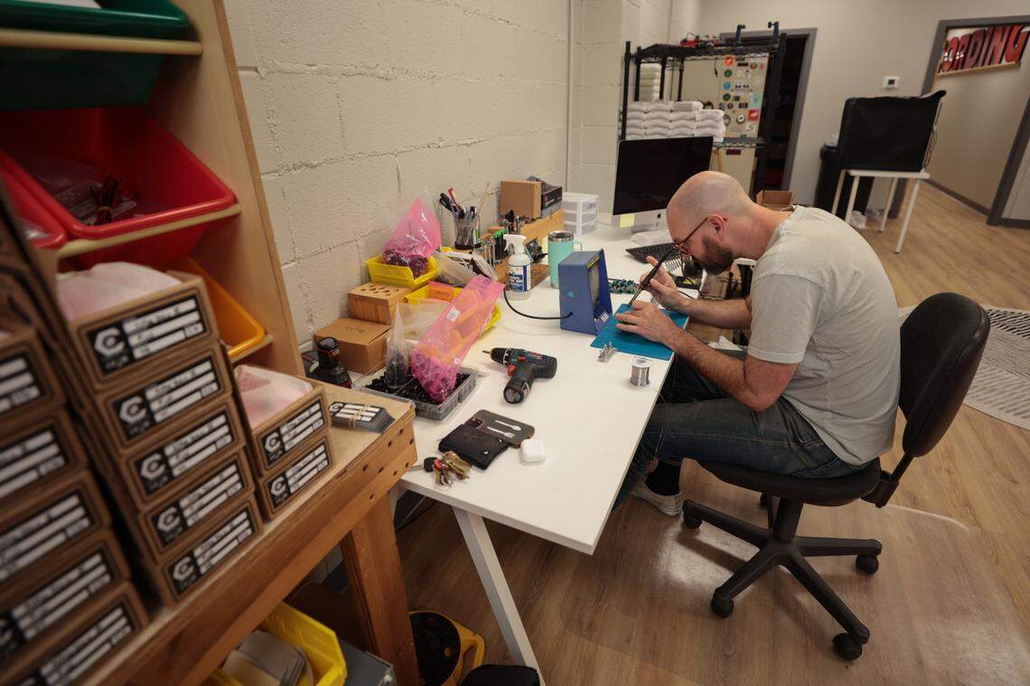 Chris Gardner assembles a guitar pedal on Wednesday, June 18, 2025 at River Drive Creative. The business houses Archer Avenue Studio and Caroline Guitar Company.