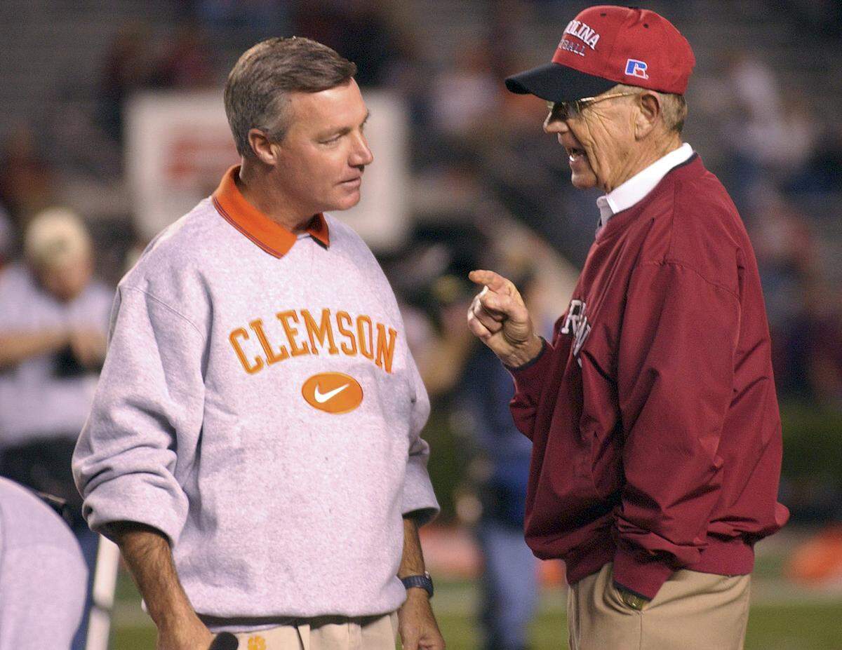 Clemson head coach Tommy Bowden (left) greets USC head coach Lou Holtz on the field during warmups on Nov. 22, 2003,  prior to the start of the game at Williams-Brice Stadium.