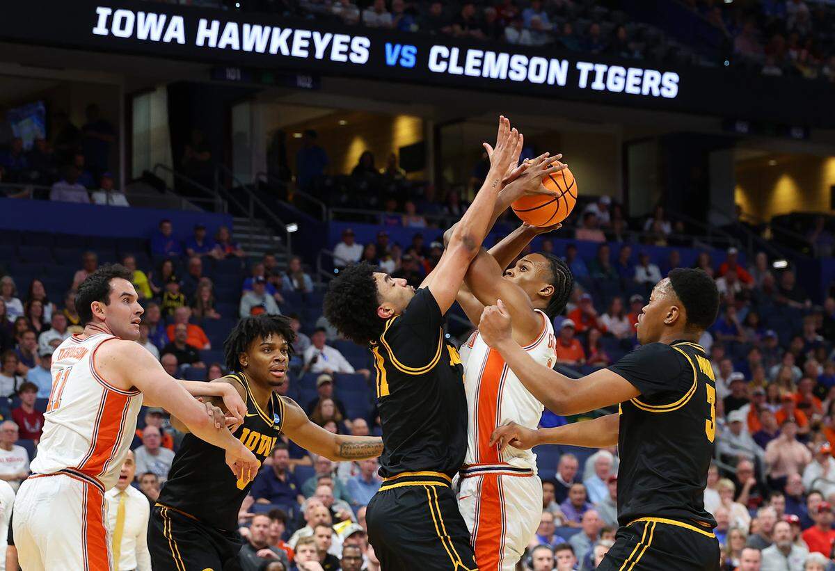 RJ Godfrey (0 )of the Clemson Tigers attempts to shoot the ball between Kael Combs (11) and Cam Manyawu (3 )of the Iowa Hawkeyes during the first half in the first round of the 2026 NCAA Men's Basketball Tournament at Benchmark International Arena on March 20, 2026 in Tampa, Florida.