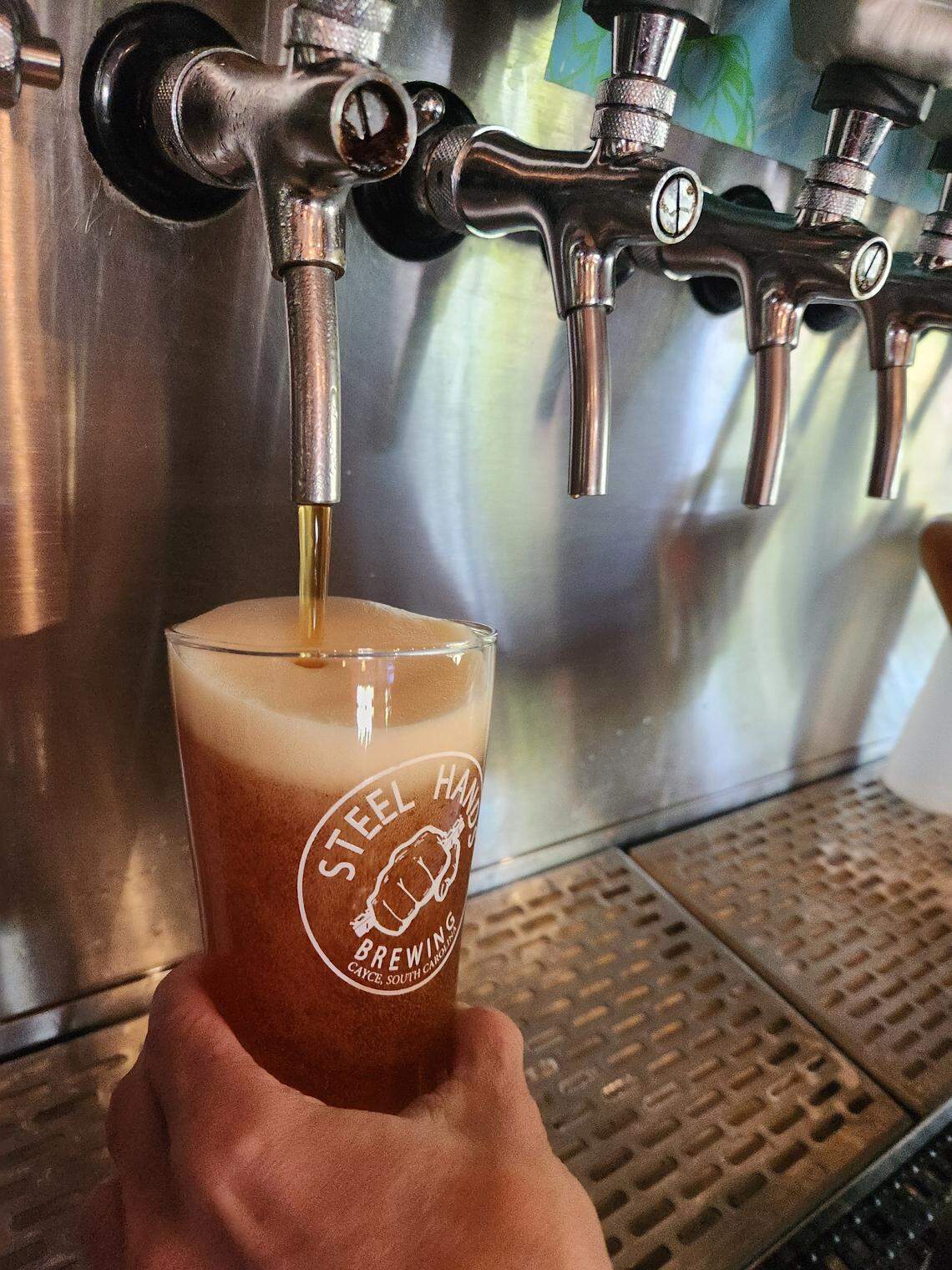 A glass of Garnet & Black Lot Lager from Spur City Brewery being poured at Cayce’s Steel Hands on April 15, 2026.