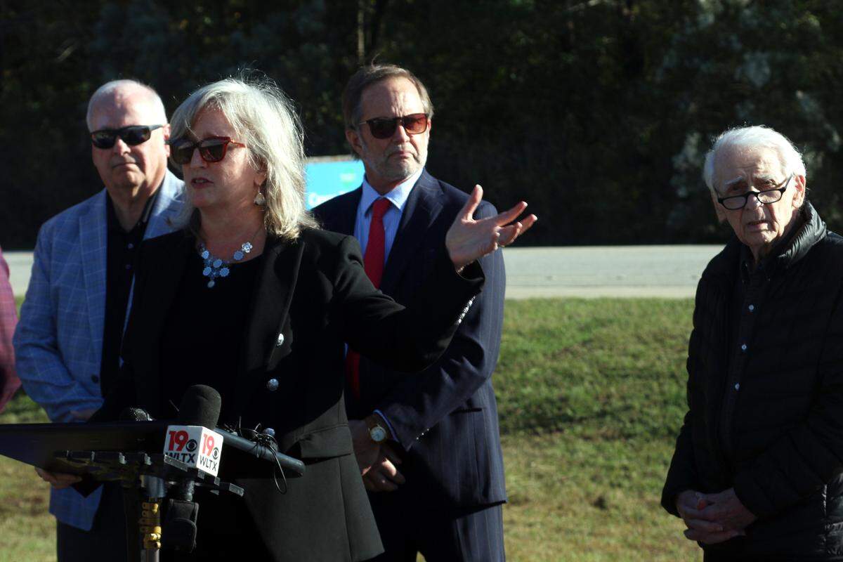Ozzie Naglar (right) looks on as Cayce Mayor Elise Partin announces that a $2.1 million donation from the Darnall W. and Susan F. Boyd Foundation will allow the city to build a visitors center at its 12,000 Year History Park. Naglar drew the first conceptual designs of the center in 1996.