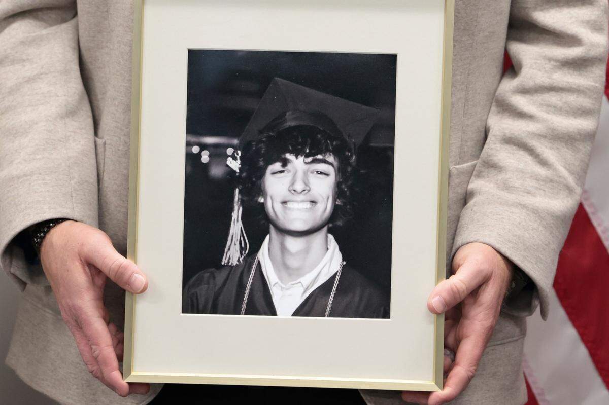 Brandon Guffey holds a photograph of his son, Gavin Guffey, during a press conference after the indictment of a Nigerian man who is charged with extortion of a South Carolina minor on Monday, Jan. 27, 2025. Gavin Guffey, 17, took his own life in 2022 after becoming the victim of sextortion.
