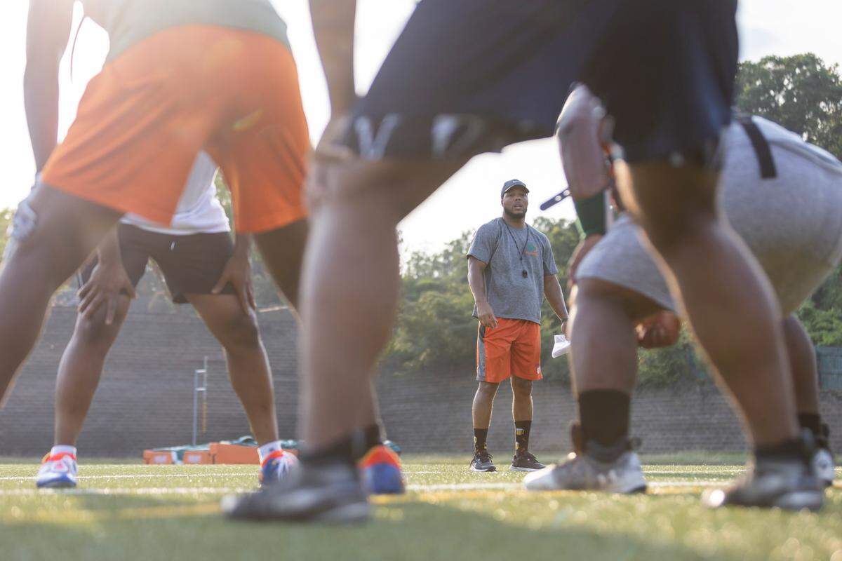 Head coach DeMarcus Simons watches his players during practice at Eau Claire High School on Tuesday, August 22, 2023.