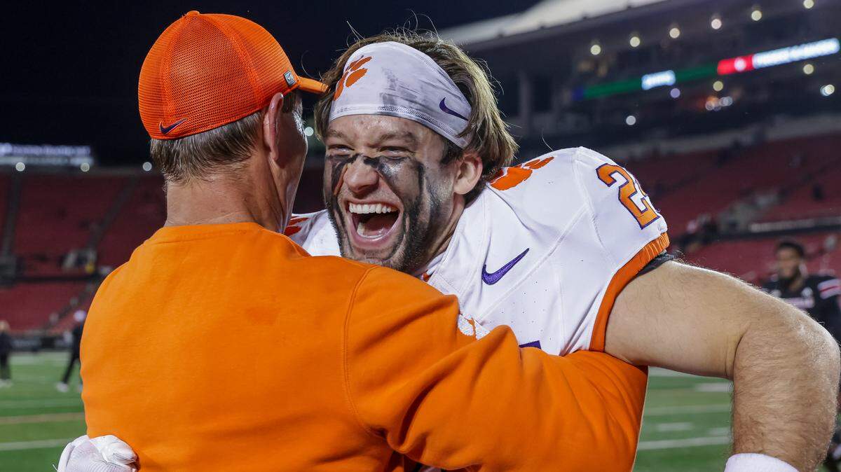 Head coach Dabo Swinney of the Clemson Tigers celebrates with Tyler Venables #24 of the Clemson Tigers after the NCAA football game between the Louisville Cardinals and the Clemson Tigers at L&N Federal Credit Union Stadium on November 14, 2025 in Louisville, Kentucky.