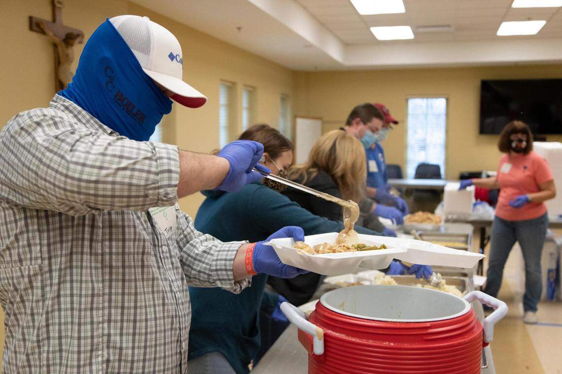 Members of churches across Columbia prepare a Thanksgiving lunch at The Basilica of St. Peter in downtown Columbia, South Carolina on Thursday, November 26, 2020. Traditionally the church’s Thanksgiving meal is help at the Carolina Coliseum, but due to measures to help stop the spread of the coronavirus, the church decided to give take-away meals at the church.