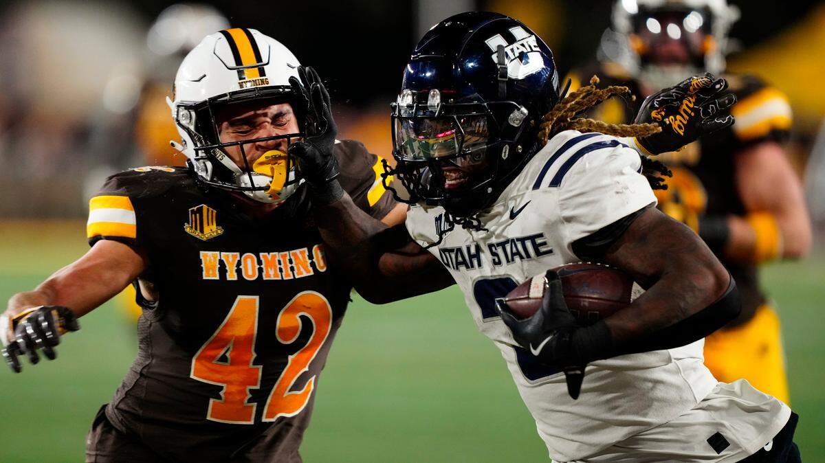 Utah State Aggies running back Rahsul Faison (3) runs against the Wyoming Cowboys during a 2024 game.