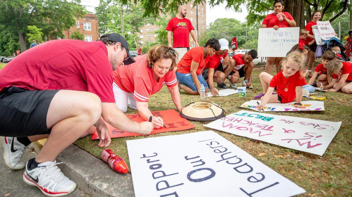 Zach Jordan, left, helps his mother, Pattie Clark, a retired art teacher, make signs for the SC for ED rally to the South Carolina State House Wednesday May 1, 2019, in Columbia. An estimated 10,000 students, teachers and advocates marched.

