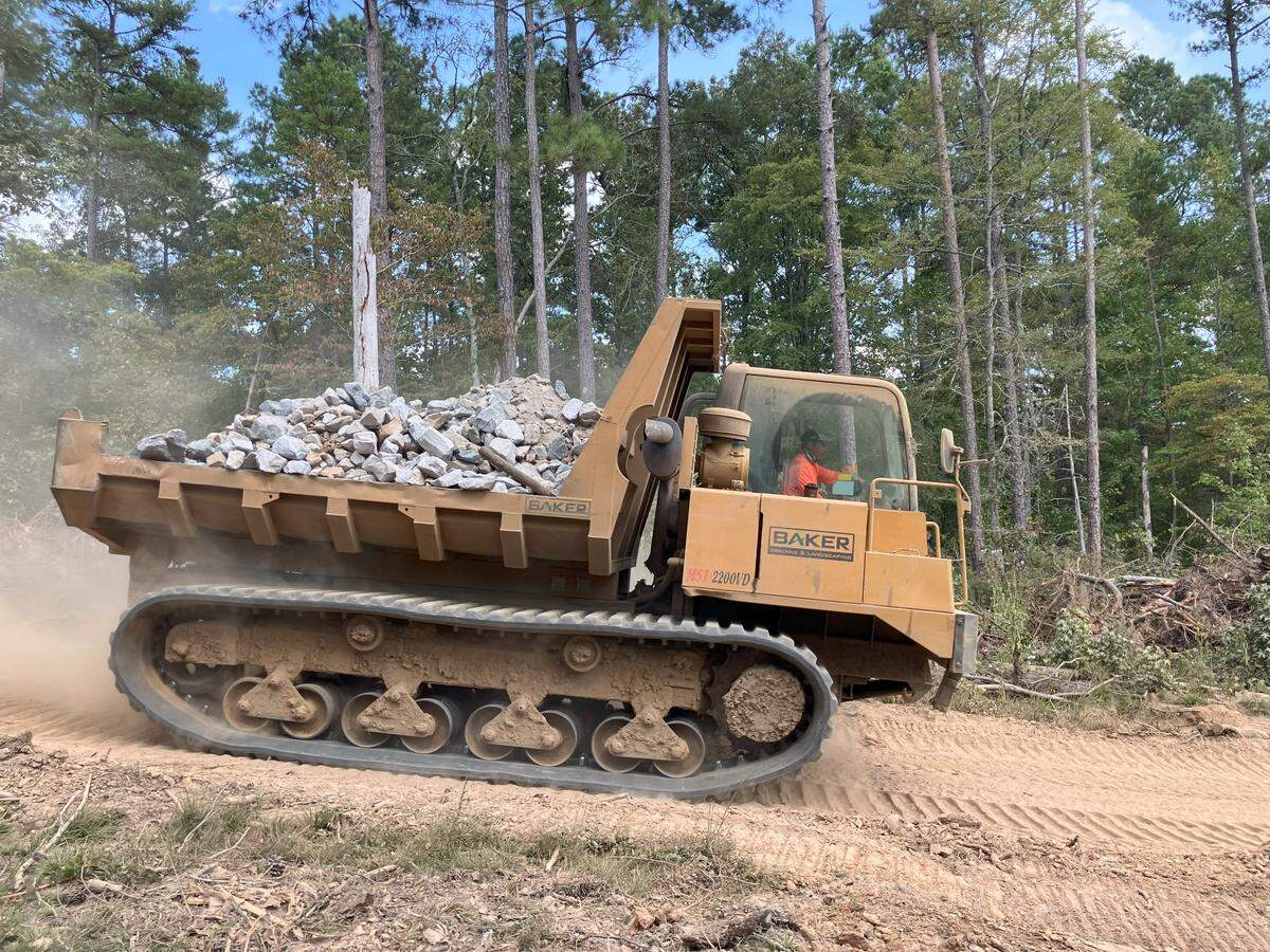 Heavy machinery carries boulders and rocks to a stream bed in the Sumter National Forest in Chester County. The work is intended to restore eroded creeks to their natural condition, but critics say it’s an expensive project and not worth clearing trees that have grown up in the past century. The work is being done as part of the offset for environmental damage at the Scout Motors project in Richland County. (photo taken Sept. 24, 2025)