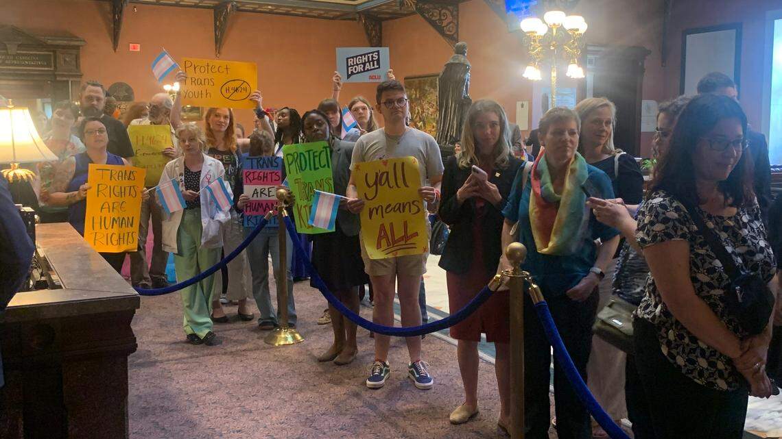 Demonstrators speaking against the proposed “Help not Harm” bill, which would prevent a minor’s gender transition, wait outside the South Carolina Senate chambers at the State House on Wednesday, May 1, 2024.