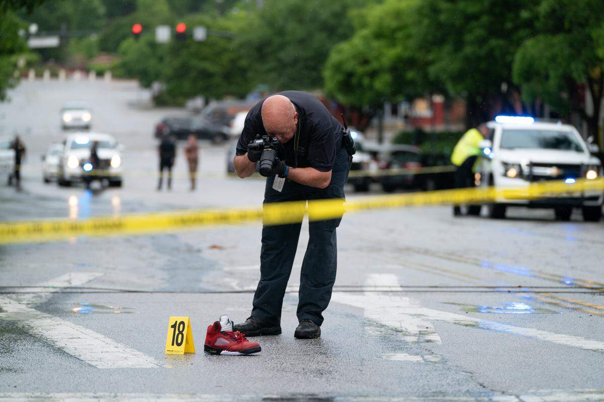 A police investigator photographs a shoe left in the middle of Greene Street after a shooting in Five Points May 4, 2021 in Columbia, SC. Photo by Sean Rayford