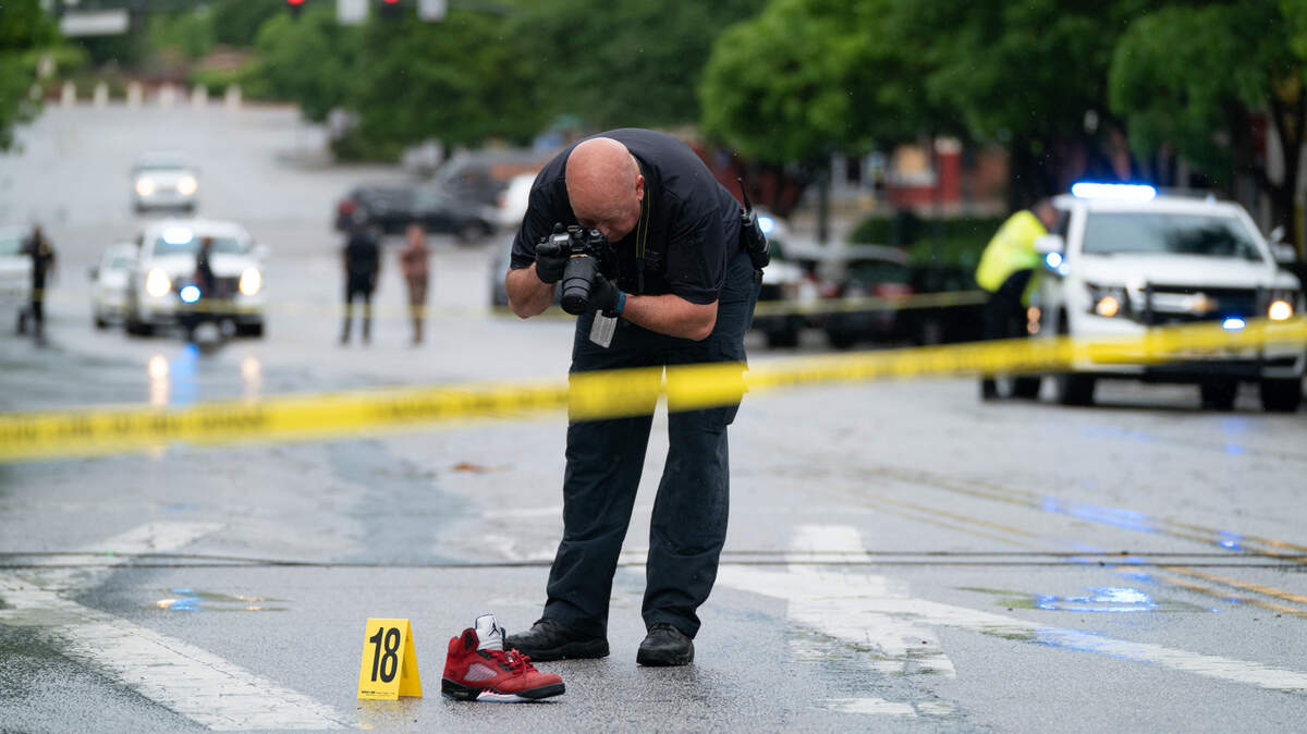 A police investigator photographs a shoe left in the middle of Greene Street after a shooting in Five Points May 4, 2021 in Columbia, SC. Photo by Sean Rayford