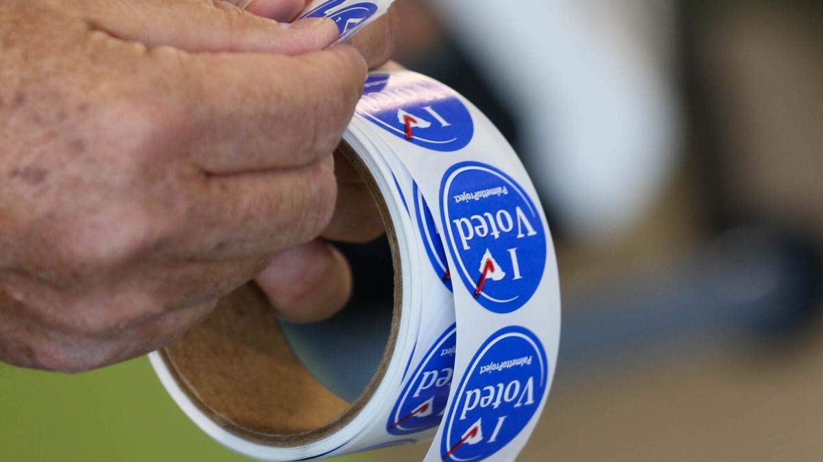 Voters are welcome to take pictures with their voting stickers outside polling locations.