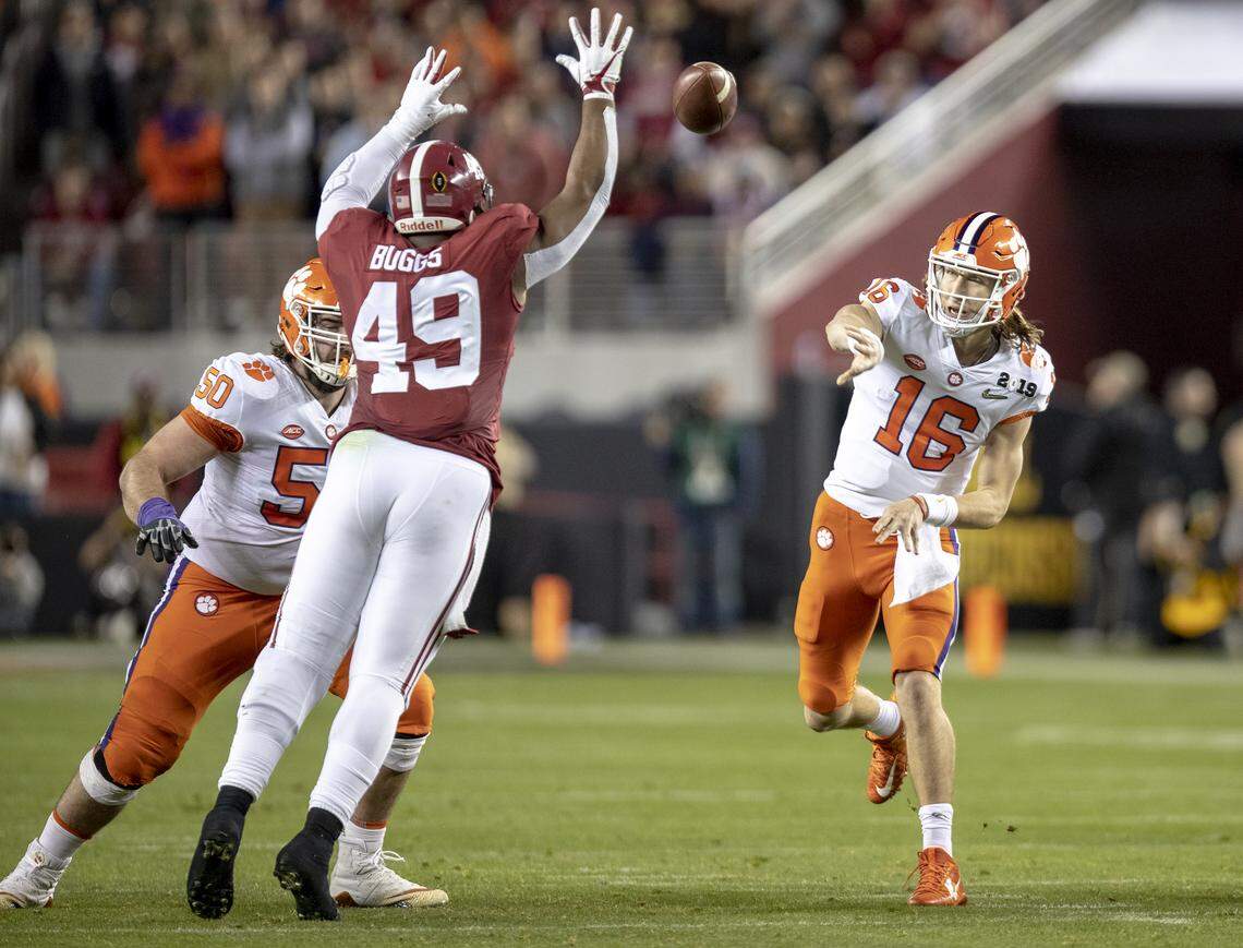 Clemson Tigers quarterback Trevor Lawrence (16) throws past Alabama Crimson Tide defensive lineman Isaiah Buggs (49) as he’s blocked by Clemson Tigers center Justin Falcinelli (50) during the College Football Playoff National Championship on Monday Jan. 7, 2019, in Santa Clara, Calif.