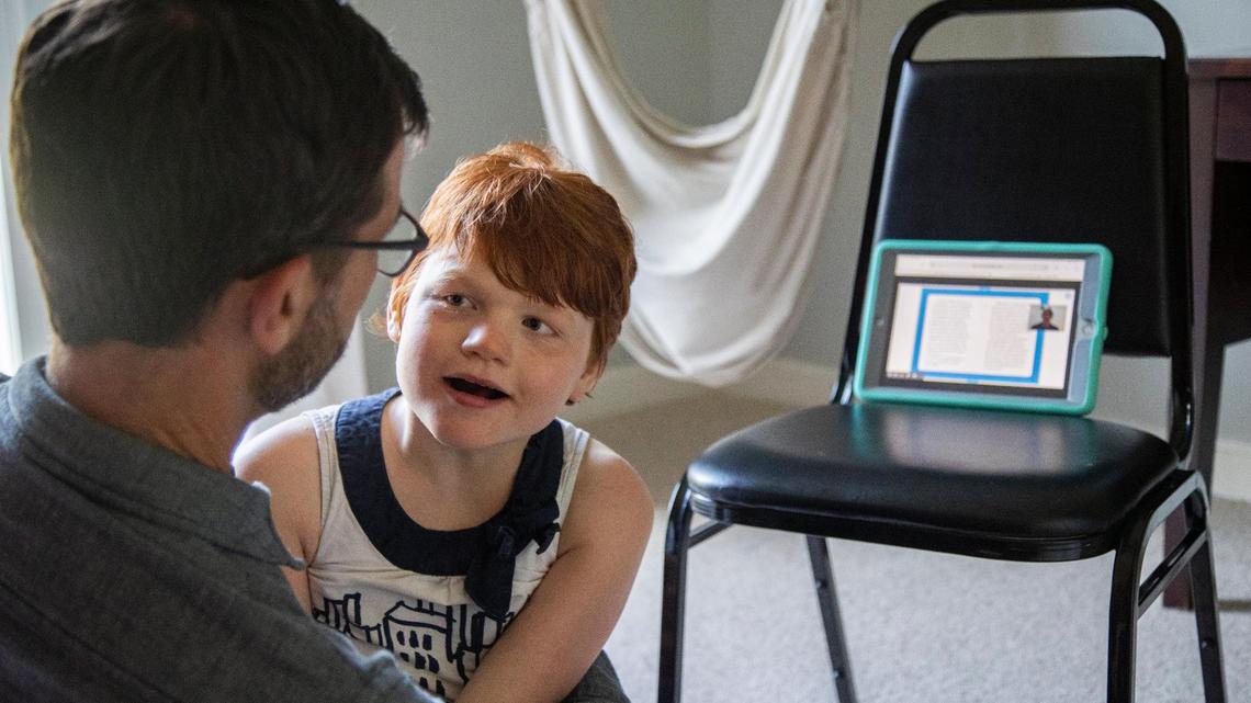 Lily Taylor, 15, sits with her father David Taylor and listens to a reading lesson on Tuesday, September 22, 2020. Lily has Angleman Syndrome, and much of the materials provided to her by her schools are not at her level and she finds hard to connect with.