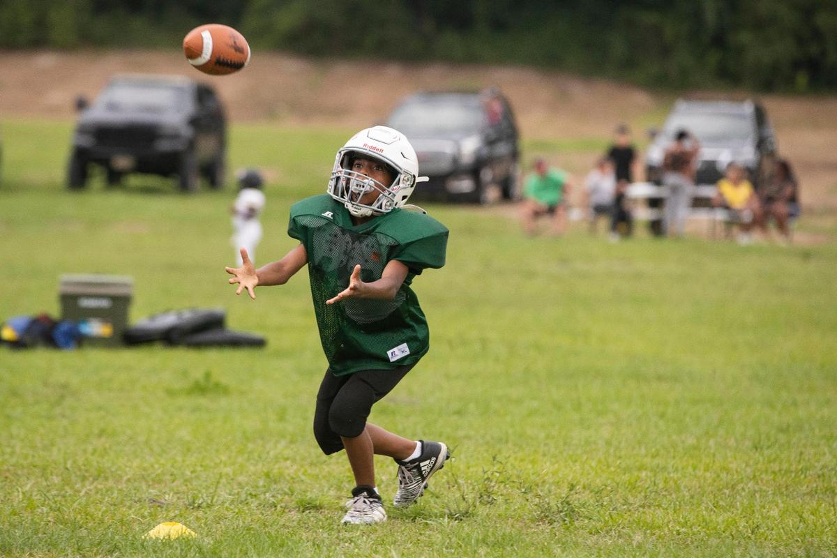 Parents watch their children play football during a Greenview Eagles practice at the former W.G. Sanders Middle School in Columbia, South Carolina on Thursday, July 7, 2022.
