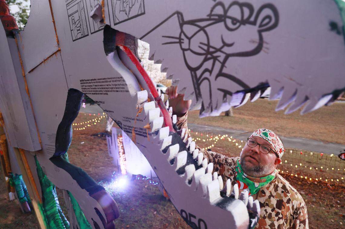 Christopher Price shows dinosaurs he made out of insulation foam outside his home on Wednesday, December 11, 2024. The dinosaurs are visible from Augusta Road in Lexington, South Carolina