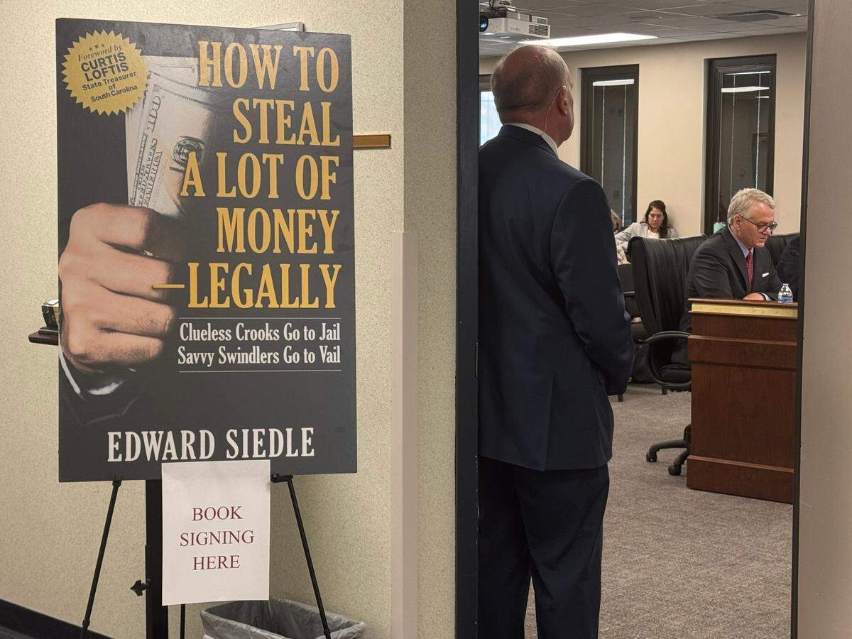 SC Senate Democrats posted a sign outside of a hearing over the $1.8 billion accounting error where Treasurer Curtis Loftis testified on Thursday, Feb. 27, 2025. Loftis wrote the forward to the book “How to Steal A Lot of Money Legally.”