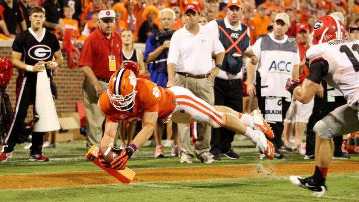 Clemson’s Stanton Seckinger dives into the end zone for a touchdown in front of Georgia’s Connor Norman during fourth-quarter action in Clemson, S.C. on Saturday, Aug. 31, 2013. The Tigers and Bulldogs meet again on Saturday at Bank of America Stadium in Charlotte for the next chapter of the rivalry.
