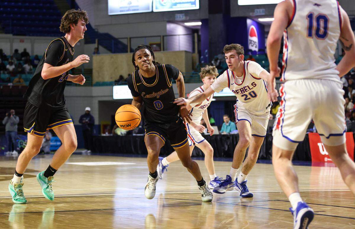 Kaleb Evans (0) of Lexington drives past Evan Enos (20) of James F. Byrnes during the first half of Lexington’s game against James F. Byrnes in the SCHSL 5A Boys Basketball State Final at the Florence Center on Friday, March 1, 2024.