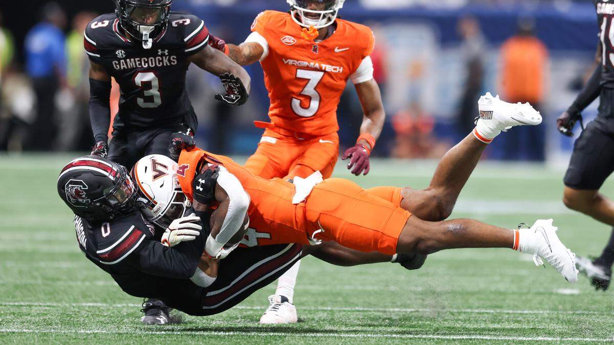 South Carolina linebacker Fred Johnson (0) wraps up Virginia Tech running back Jeremiah Coney (4) on Sunday at Mercedes-Benz Stadium in Atlanta. The Gamecocks and Hokies faced off Aug. 31 in the 2025 Aflac Kickoff Game.