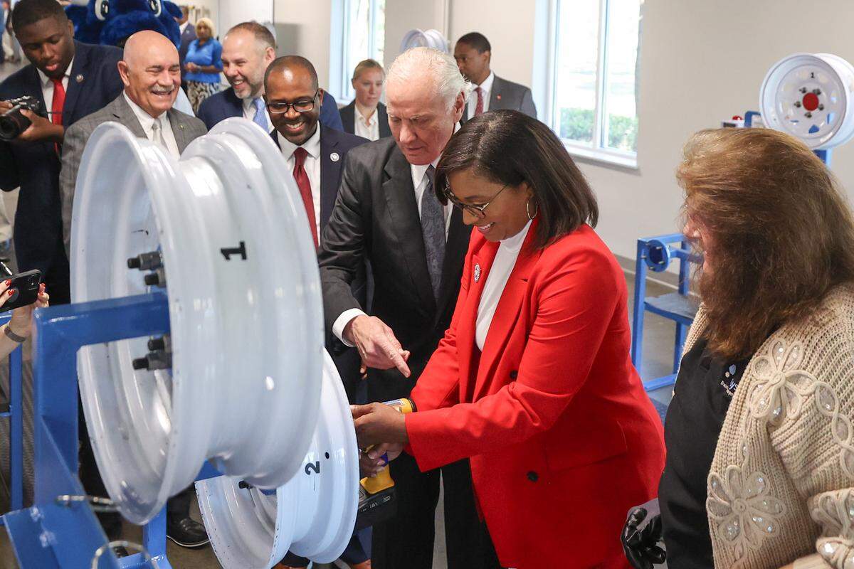 S.C. Gov. Henry McMaster and Richland County councilwoman Jesica Mackey work at a wheel mounting station in the new training area at the Cornerstone Economic Development and Workforce Training Center at Midlands Technical College. The center is being used to screen applicants for Scout Motors.