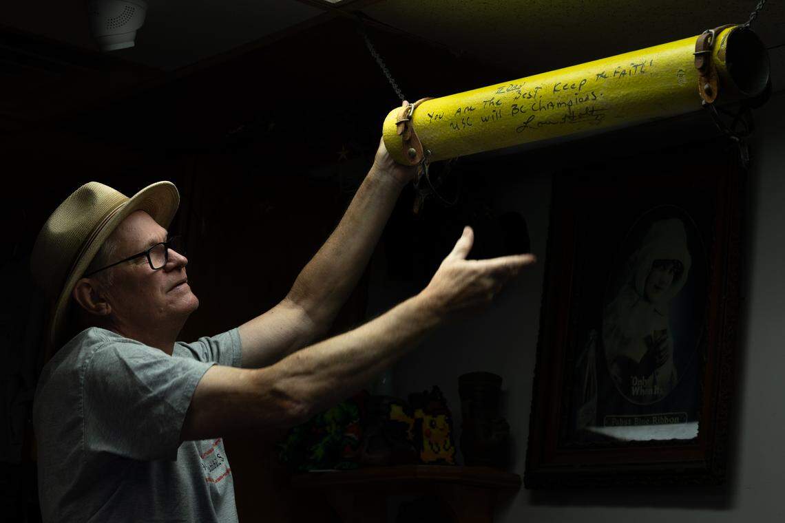 Marty Dreesen, on Wednesday, Sept. 3, 2025, adjusts the section of the USC goal post displayed at Bar None in Columbia’s Five Points. It is signed by then USC football coach Lou Holtz.