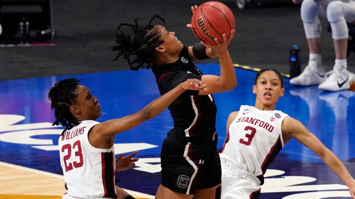 South Carolina guard Zia Cooke, center, drives to the basket between Stanford guard Kiana Williams (23) and guard Anna Wilson (3) during the first half of a women’s Final Four NCAA college basketball tournament semifinal game Friday, April 2, 2021, at the Alamodome in San Antonio.