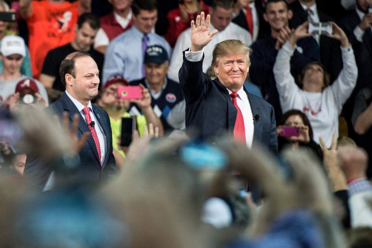 Then Republican presidential candidate Donald Trump is introduced to the crowd at a town hall meeting December 12, 2015, in Aiken, South Carolina as South Carolina Attorney General Alan Wilson watches.