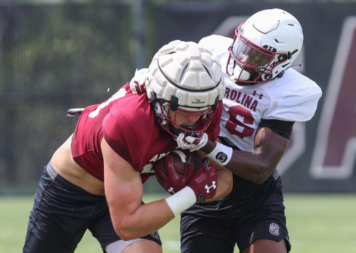 South Carolina tight end Nick Elksnis (84) carries the ball as he gets wrapped up by defensive back Vicari Swain (16) runs drills during practice in Columbia on Monday, August 7, 2023.