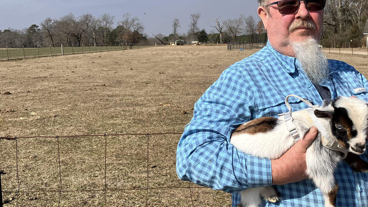 Farmer Robbie O’Neal holds his pet goat Feb. 10 while standing in front of an agricultural field that today is polluted with toxic forever chemicals. The family allowed industrial sludge from a textile plant to be used as a fertilizer after government regulators said it was safe.