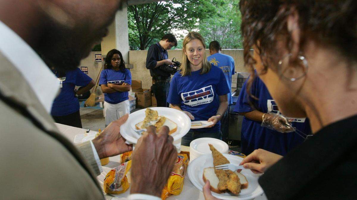Anthony Palmer (left) and his wife Eriko, (right) try out their fried fish as Margaret Cantrell (center) looks on during U.S. Rep. James Clyburn’s annual fish fry for South Carolina Democrats inside the South Carolina Municipal Association garage in downtown Columbia, Friday, April 27, 2007.