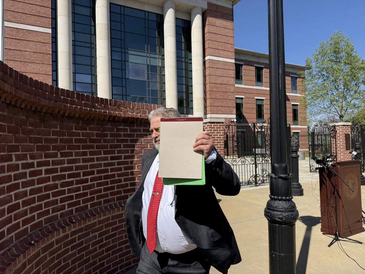 Charles George, the S.C. attorney for hate crime defendant Jonathan Felkel, walked by reporters Thursday and held a pad up to try to block a photo.