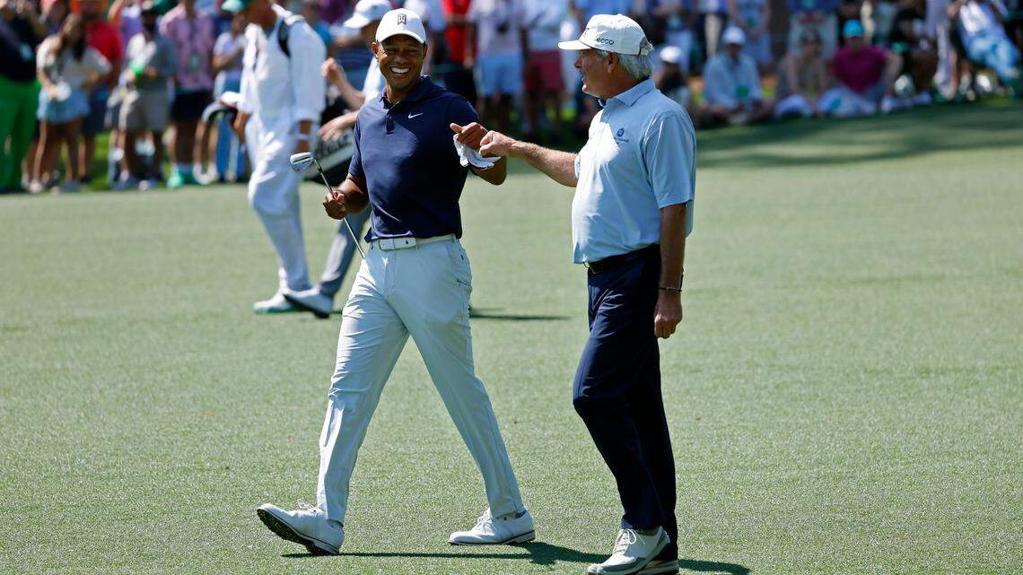 Masters champion Tiger Woods fist bumps playing partner and Masters champion Fred Couples on the No. 2 fairway during practice round 1 for the Masters at Augusta National Golf Club, Monday, April 4, 2022.