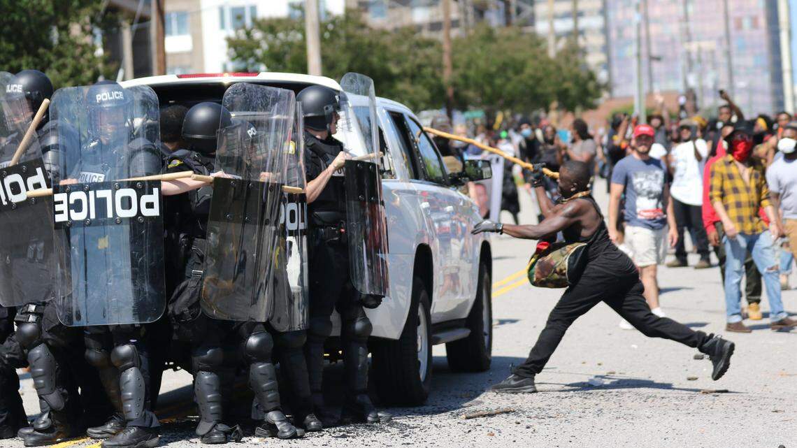 An angry protester breaks a window of a police vehicle during a protest at the Columbia police headquarters in May 2020. Demonstrators were upset over the killing of George Floyd in Minneapolis