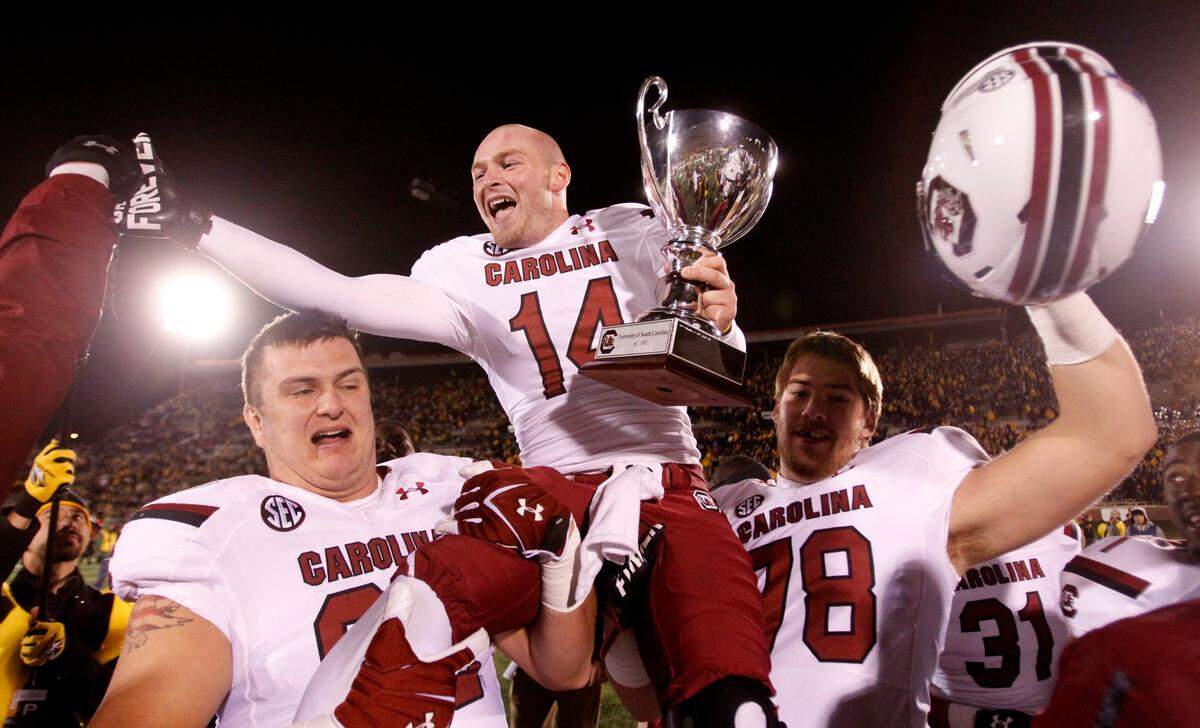 South Carolina quarterback Connor Shaw (14) celebrates with teammates after the Gamecocks’ come-from-behind overtime win over Missouri in 2013.