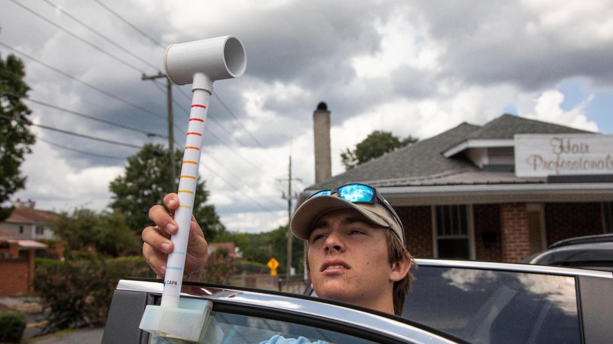 Zach Owens places a device to collect temperature data on his mother’s car door in the Forest Acres neighborhood on Saturday, August 6, 2022. Owens is considering studying climate science in college, and was excited to get experience gathering the data.