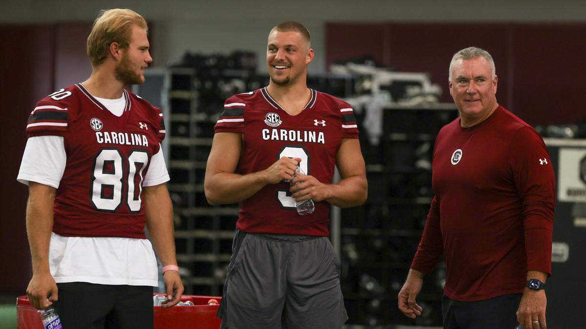 Tight Ends coach Shawn Elliott talks with Lukas Vozeh, left, and Luke Doty during media day for the University of South Carolina football team inside the Jerri and Steve Spurrier indoor practice facility.