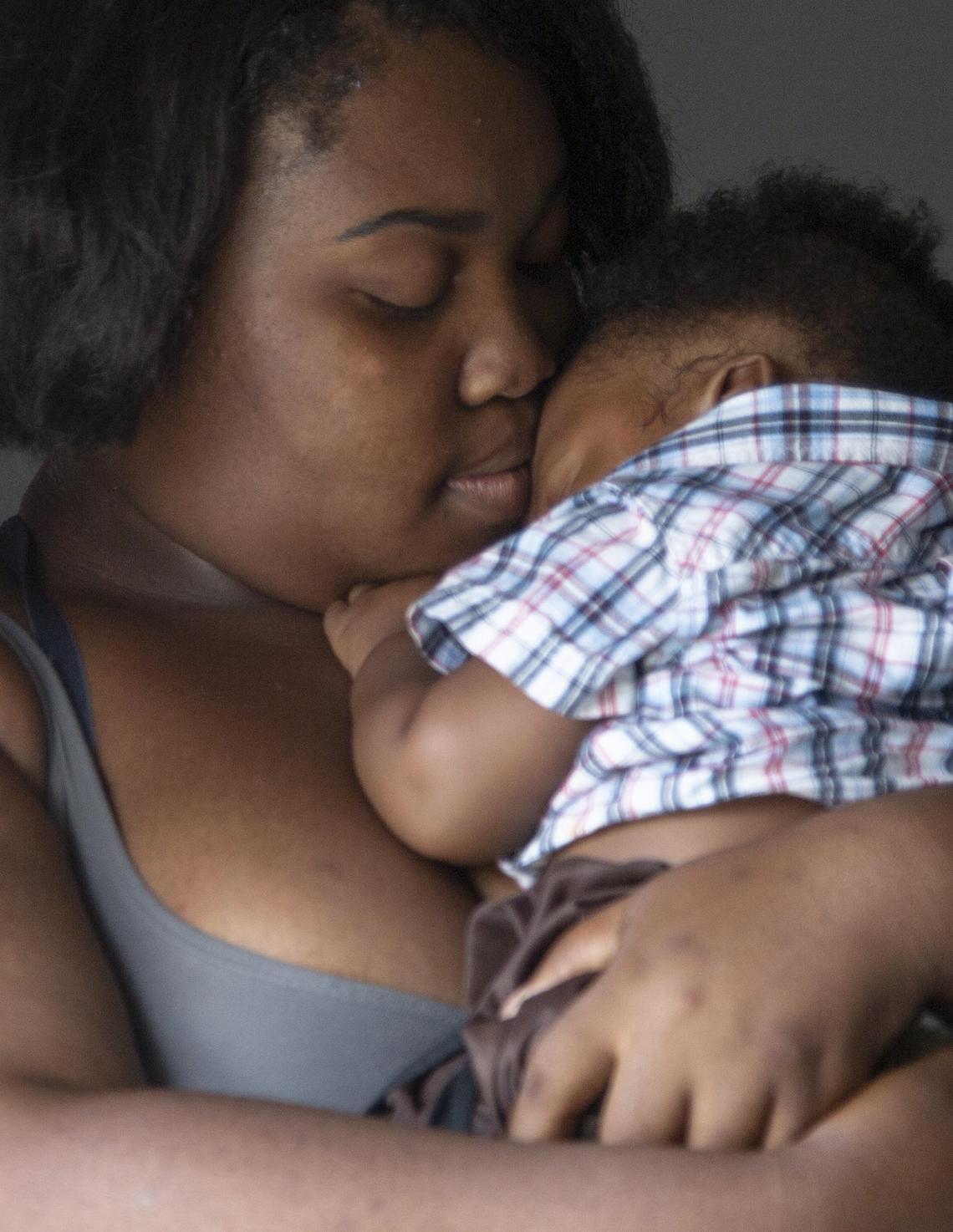 Tootie holds her 7-month-old son, Da’Yon, in her home in the North Pointe Estates. Tootie attends school to become a medical assistant to provide a better life for her son.