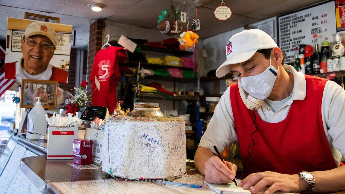 “Little” Andy Schlon takes an order over the phone at Andy’s Deli in Five Points on Wednesday, February 3, 2021. The portrait of his late father and namesake hangs near the cash register.