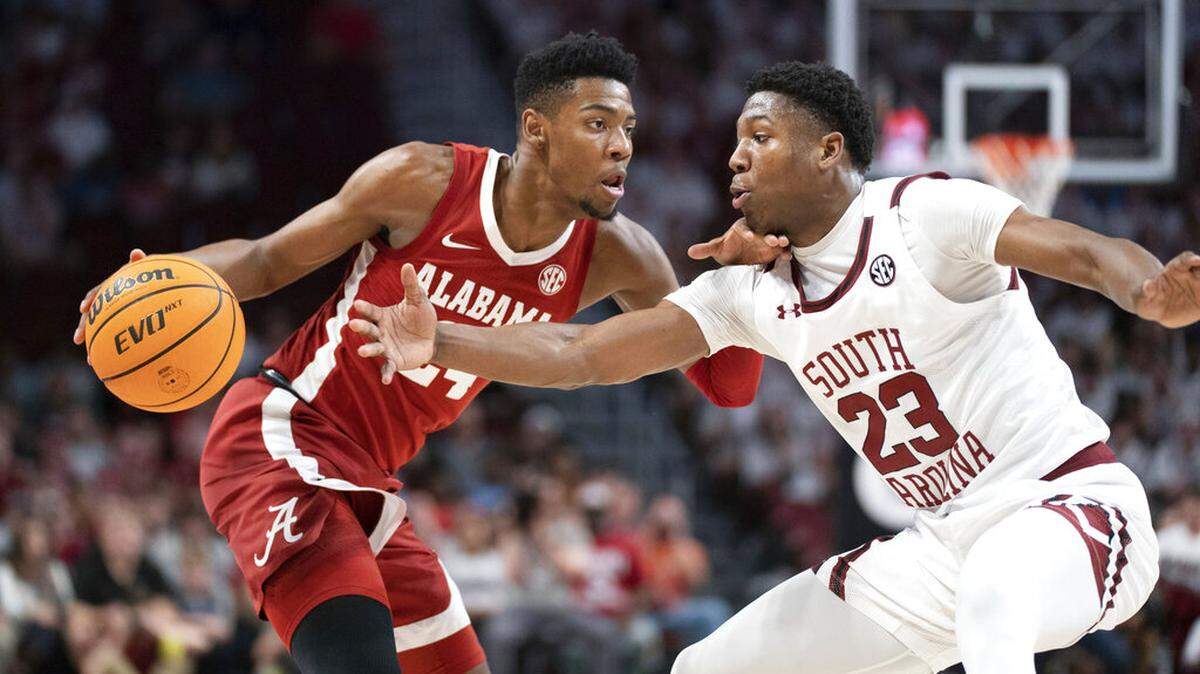 Alabama forward Brandon Miller, left, dribbles the ball against South Carolina forward Gregory Jackson II (23) during the first half of an NCAA college basketball game Wednesday, Feb. 22, 2022, in Columbia, S.C.